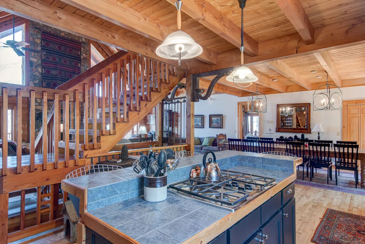 A welcoming kitchen and dining space, where a large kitchen island takes center stage. The stainless steel appliances shine, and the adjacent dining table, which easily seats a crowd, is the perfect backdrop for festive meals and family feasts. The scene feels lively and ready for memorable occasions.